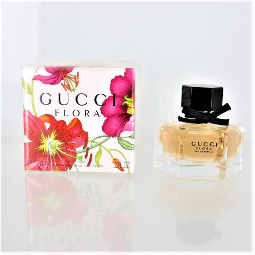 Gucci Flora perfume bottle with pink floral box, clear amber liquid, black cap