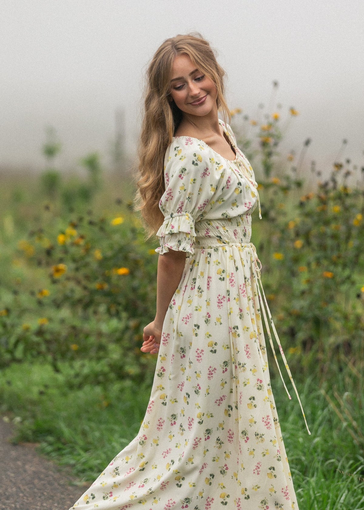 Cream floral maxi dress with short puff sleeves and cinched waist, ruffle trim.