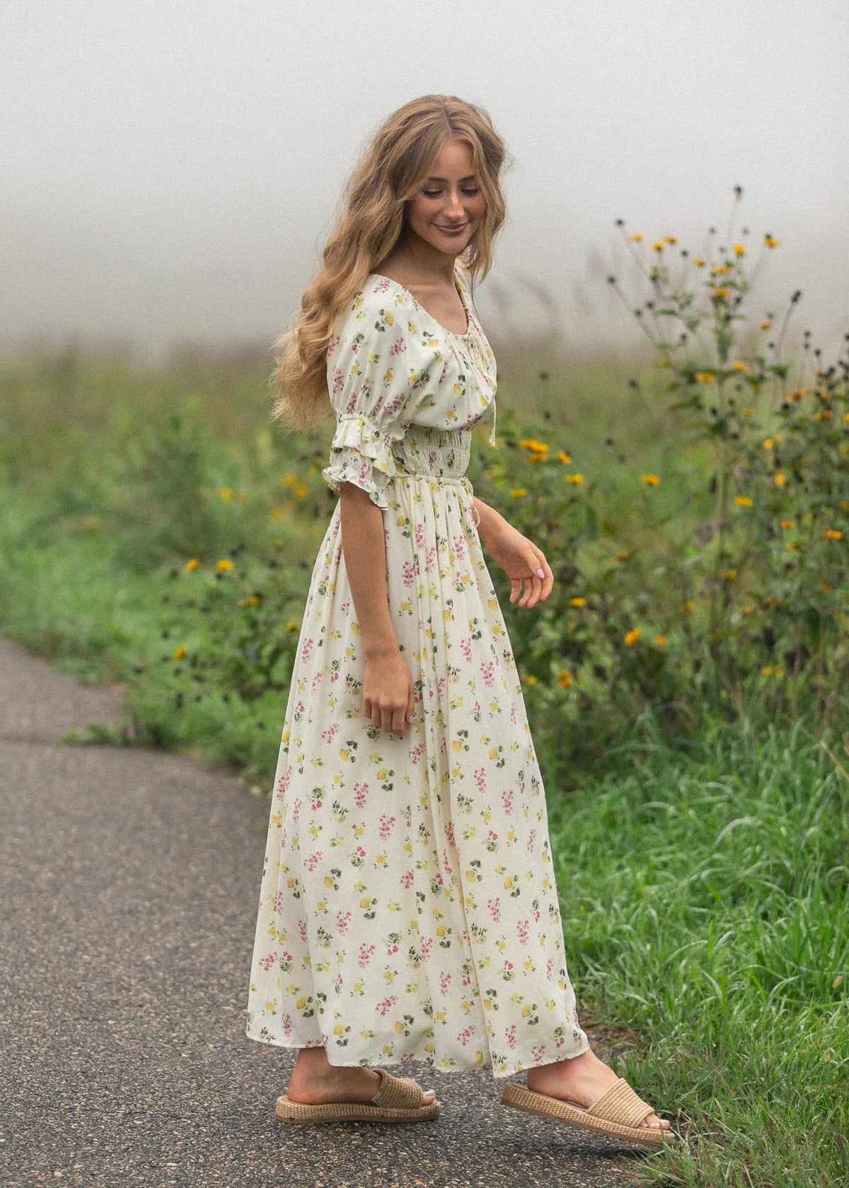 Cream floral maxi dress with puff sleeves and gathered skirt, standing full length.