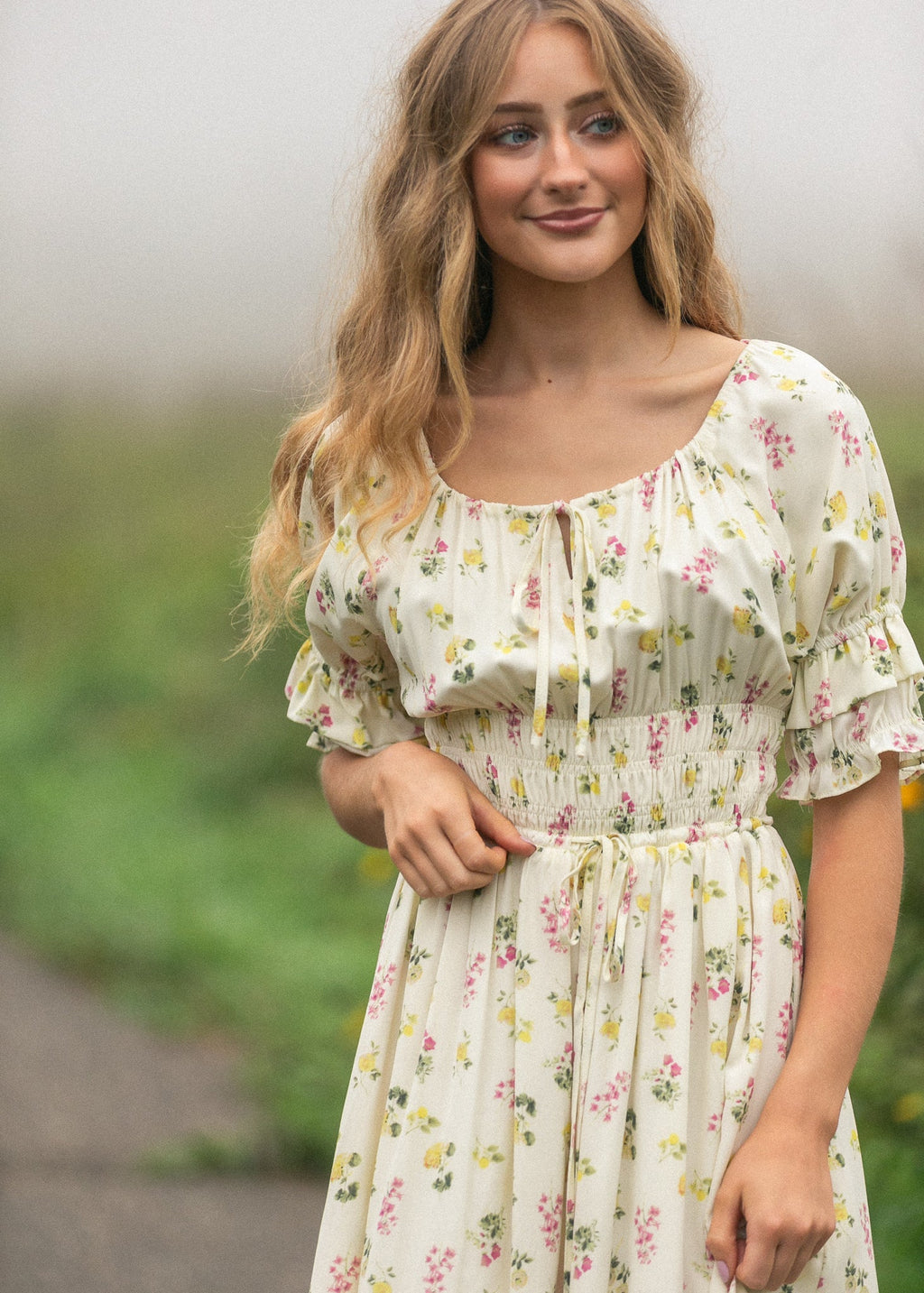 Cream floral maxi dress with puff sleeves, gathered bodice, and tied waist ribbon.