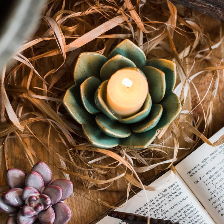 Ceramic succulent flower candle holder, teal, holds a lit tealight candle