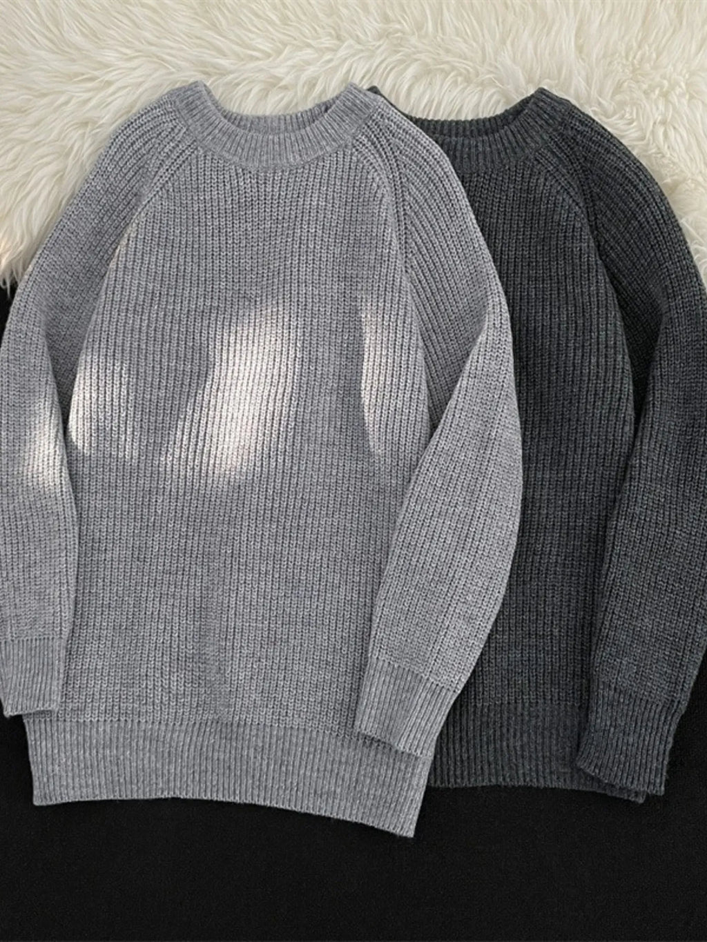 Light gray and dark gray knit round-neck long-sleeve sweaters with ribbed cuffs