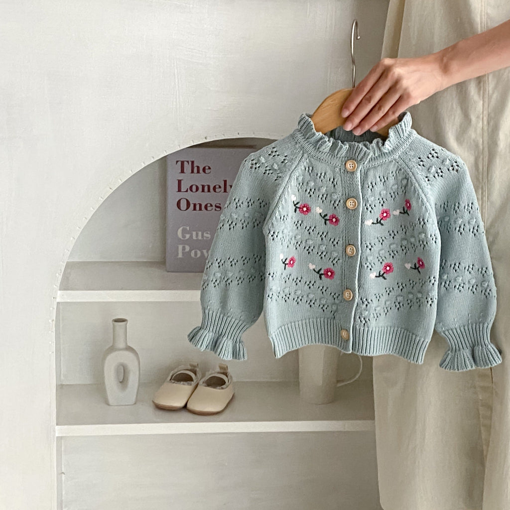 Blue-gray knit cardigan with ruffle neckline, button front, and red floral embroidery.