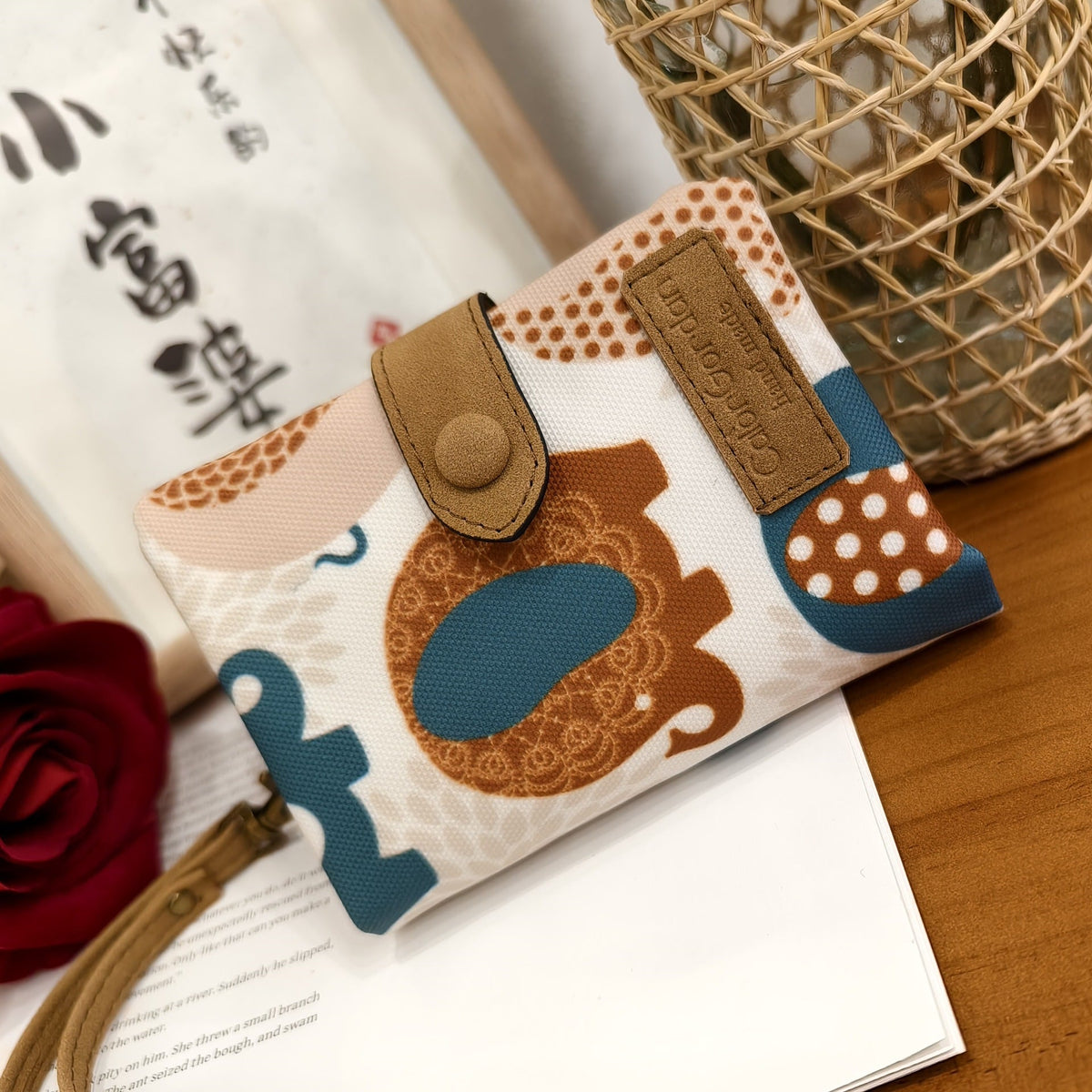 Printed tri-fold wallet with snap button and wrist strap, white and brown bear pattern