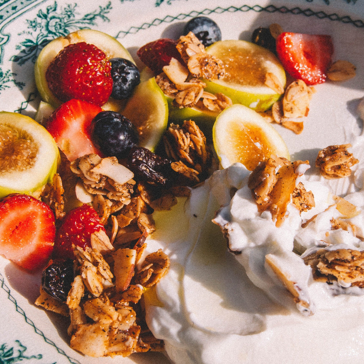 Plate of yogurt with granola and sliced fruit
