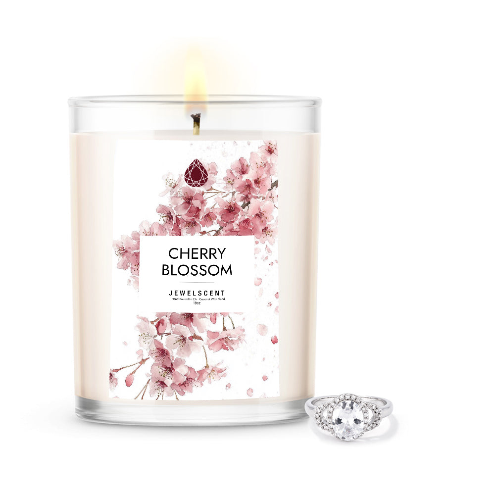 18oz cherry blossom scented candle with floral label and silver ring jewelry beside