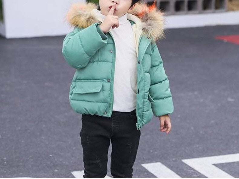 Teal kids puffer jacket with faux fur hood worn with dark pants