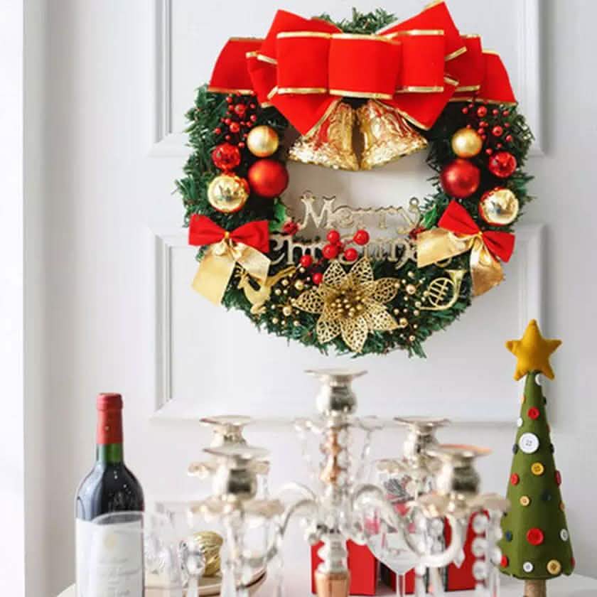 Christmas wreath door ornament with red bow, gold bells, and red-and-gold baubles