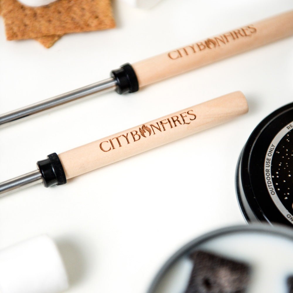 Wood-handled roasting sticks with CITYBONFIRES branding and storage tin