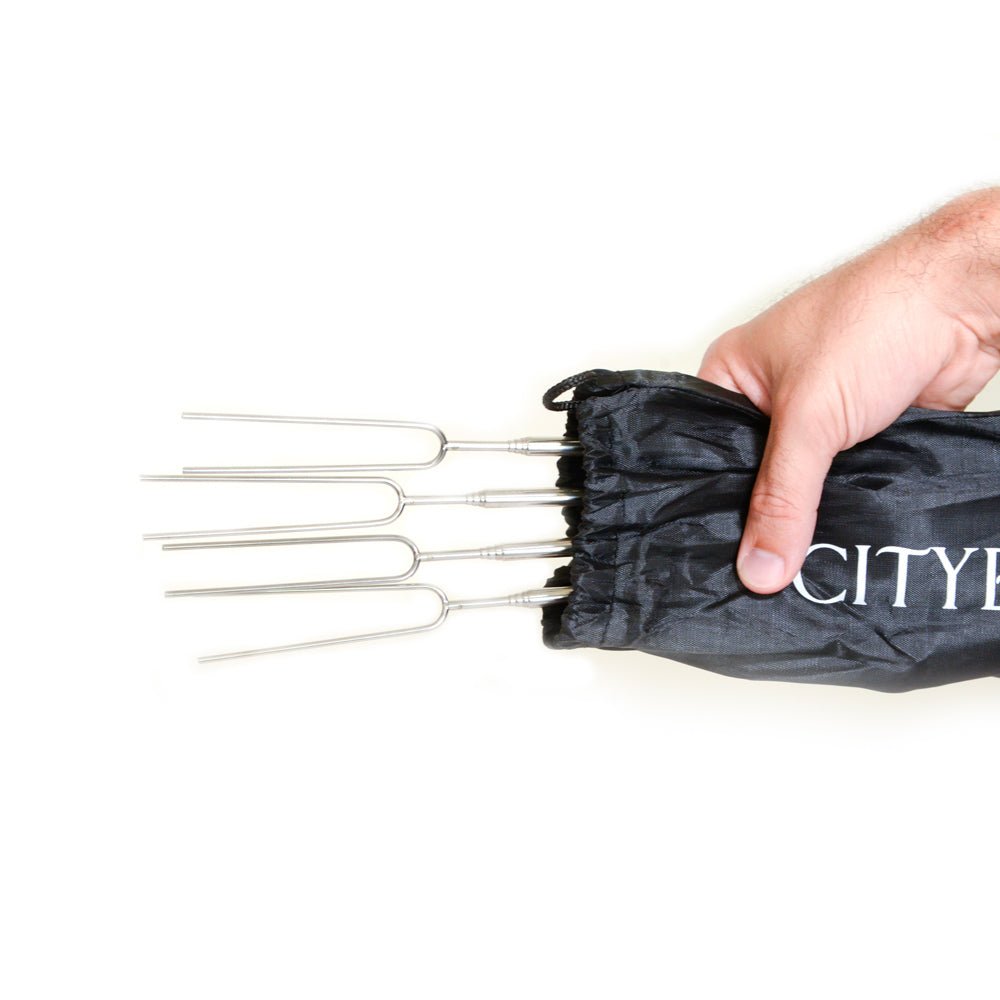 Four s'mores sticks partially inside a black drawstring carrying bag