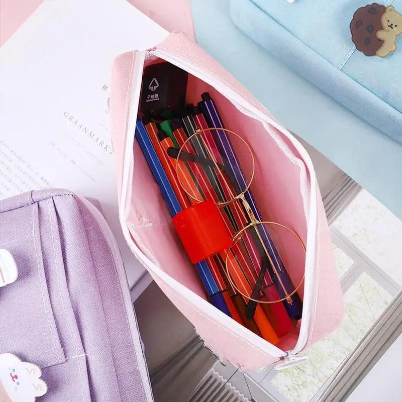 Open purple pencil pouch showing pencil slots and colorful pens inside, zip top