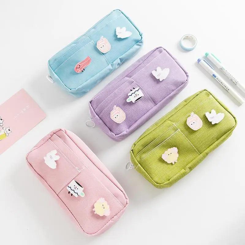 Four pastel fabric pencil pouches: blue, purple, green, and pink with animal patches