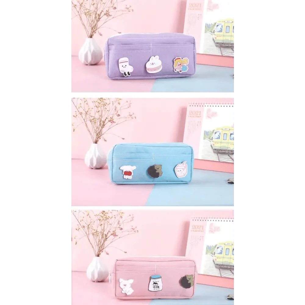 Row of pastel pencil pouches with cartoon patches in lavender, blue, and pink