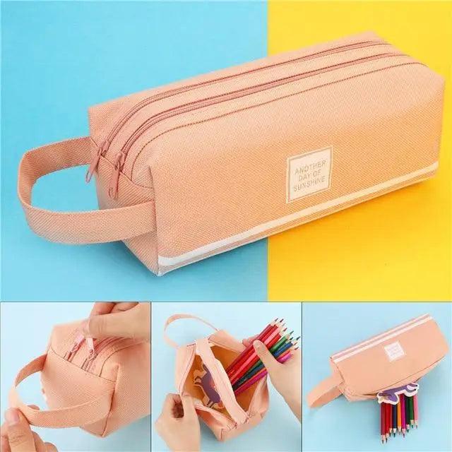 Light pink double-zip pencil pouch with wrist strap and front label badge