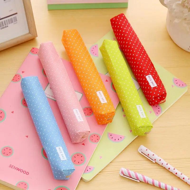 Assorted slim canvas pencil pouches with dotted prints and zipper closures.