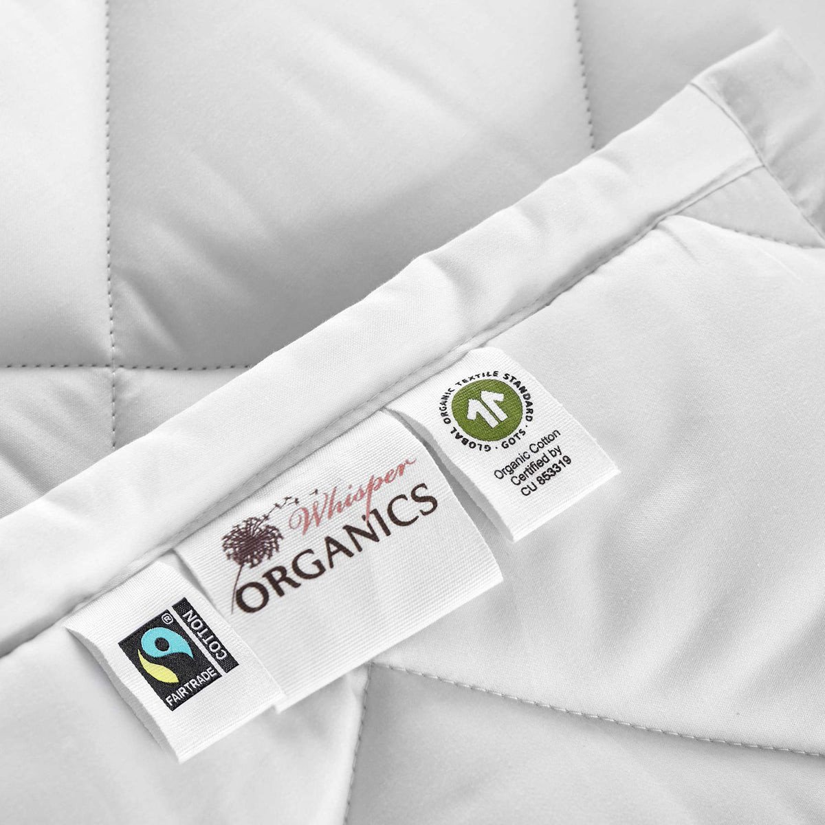 White comforter with Whisper ORGANICS and certification labels on fabric