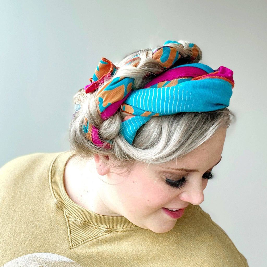Colorful headscarf with bright turquoise, pink, and orange accents on white fabric