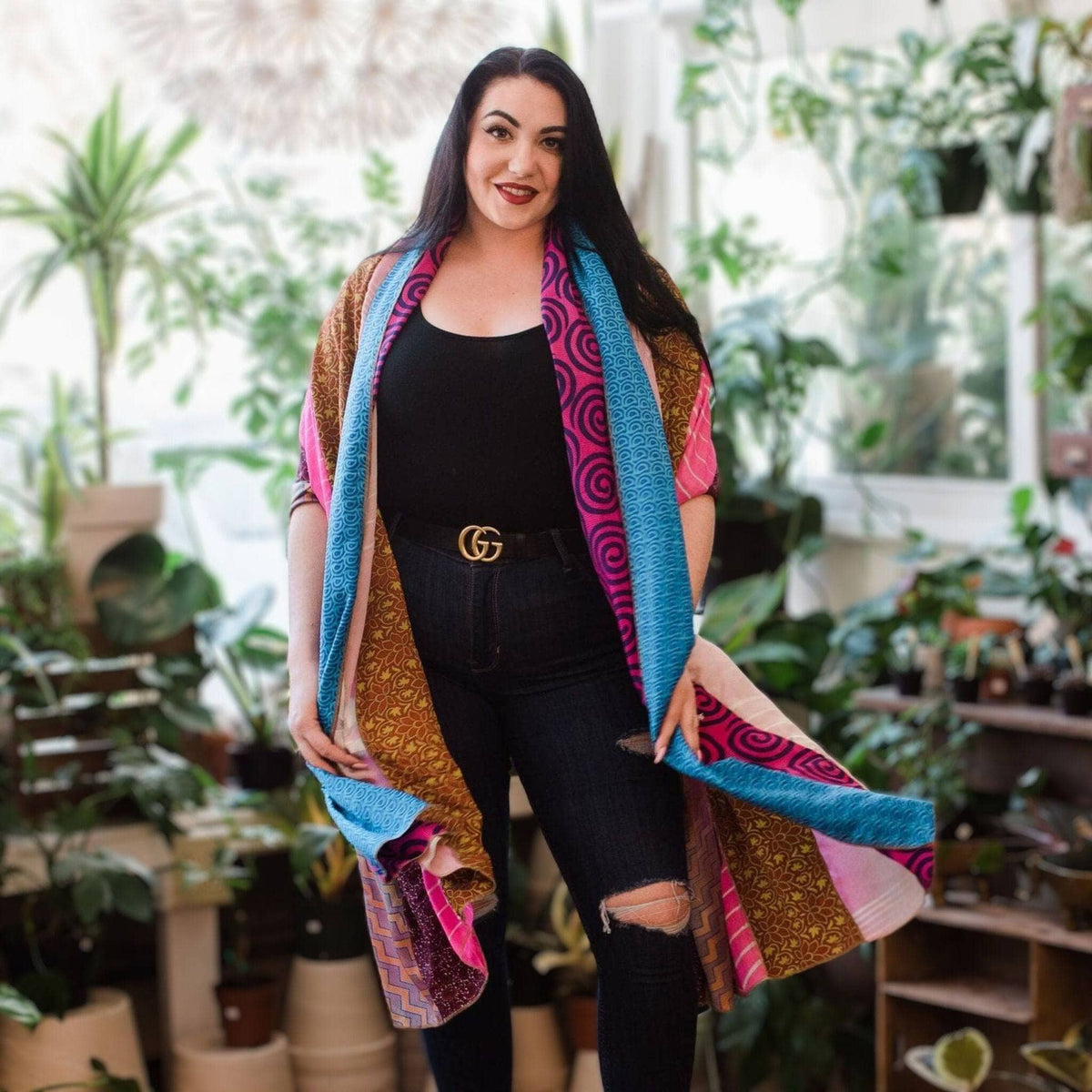 Multicolor patchwork scarf draped over shoulders with blue, pink, and golden patterns