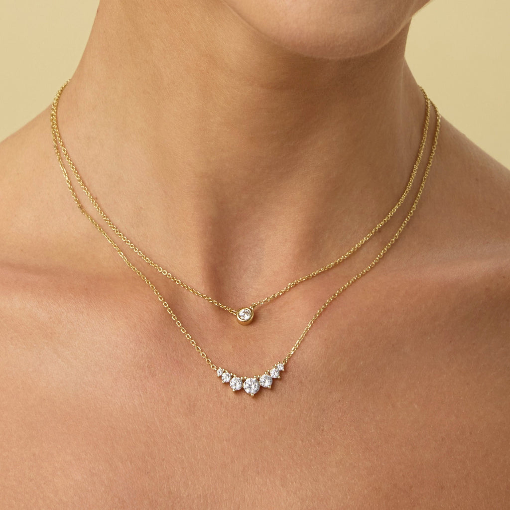 Small gold chain necklace with round bezel-set diamond pendant