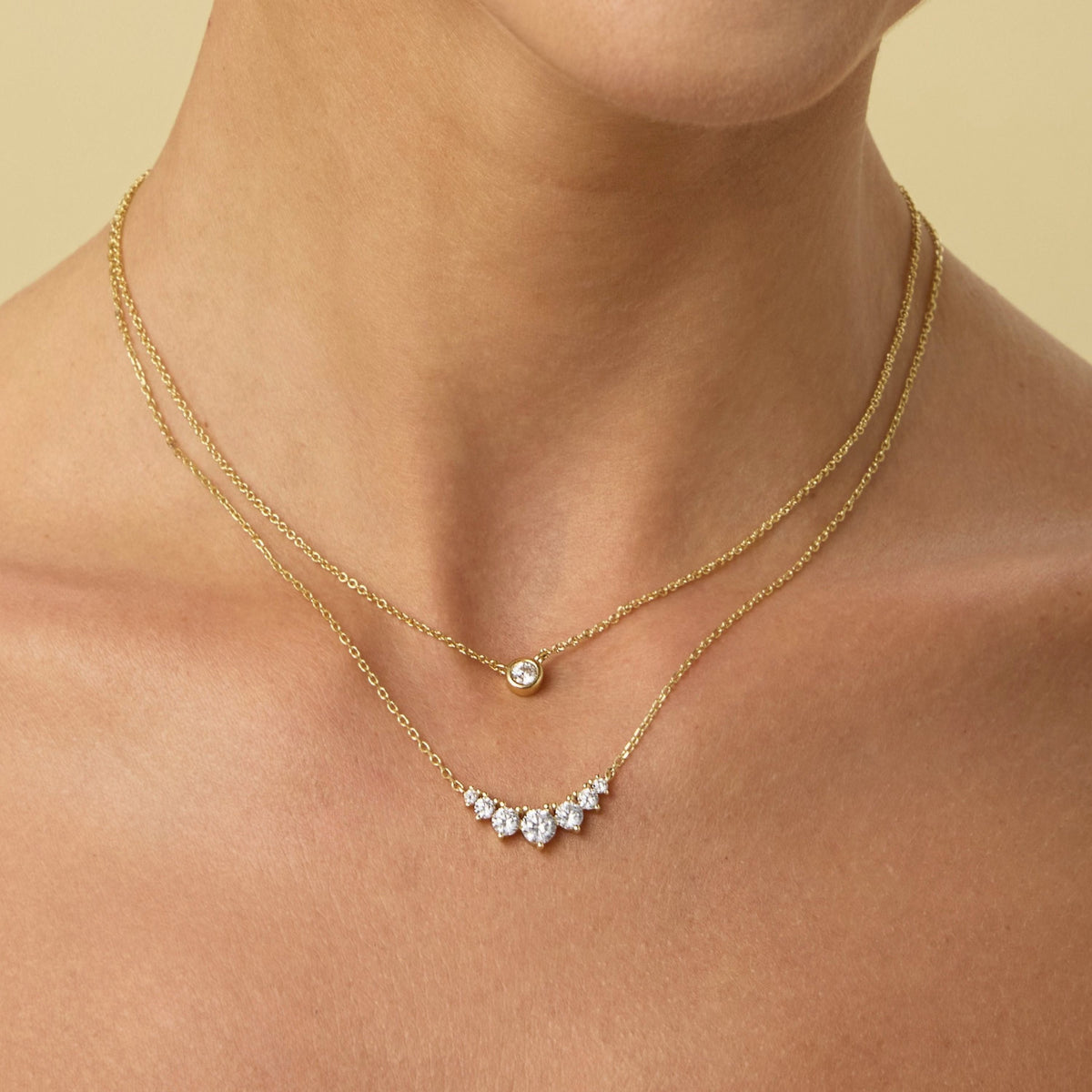 Small gold chain necklace with round bezel-set diamond pendant