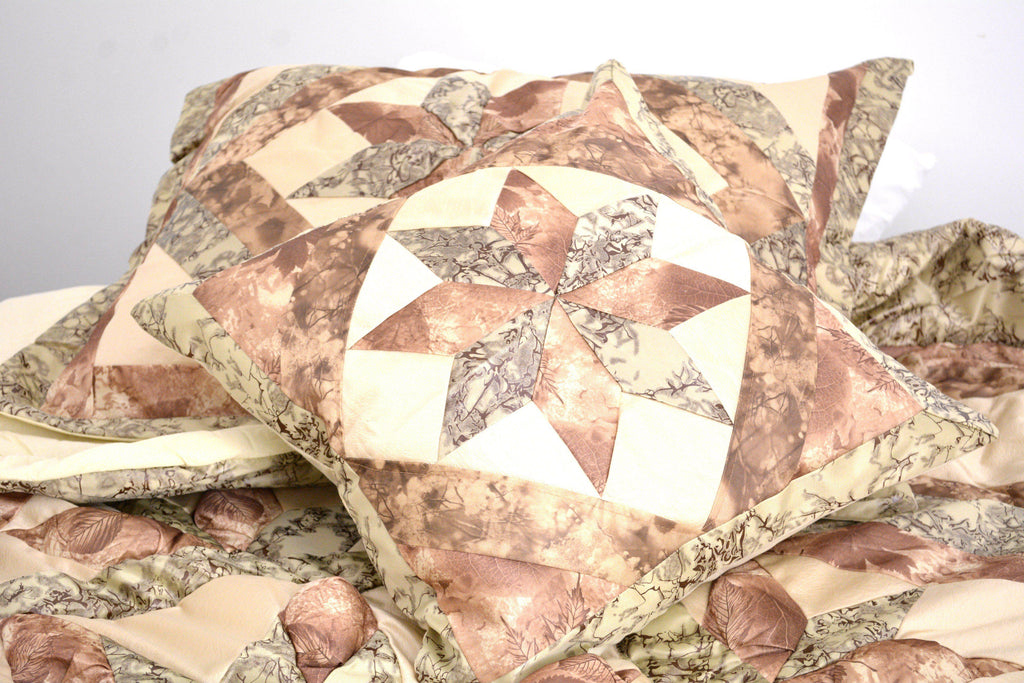 Decorative patchwork pillow with geometric shapes in beige, brown, and green