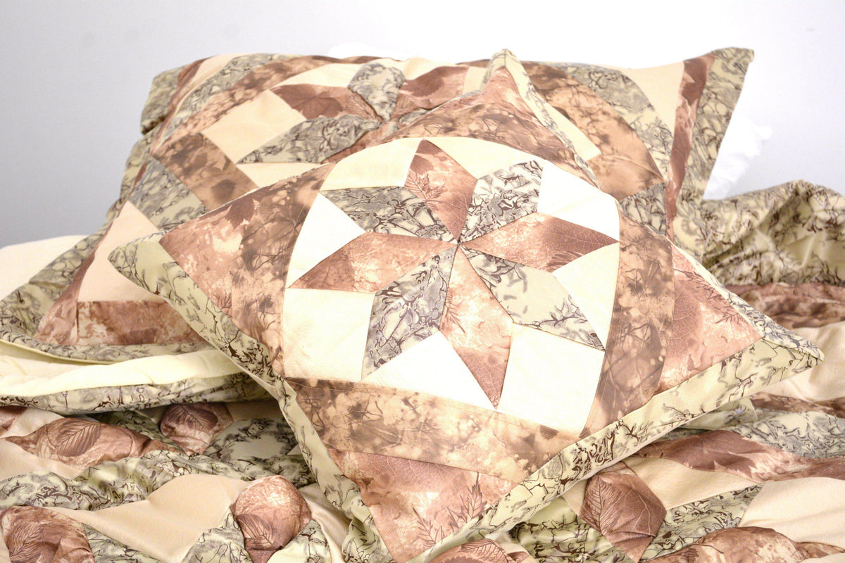 Decorative patchwork pillow with geometric shapes in beige, brown, and green