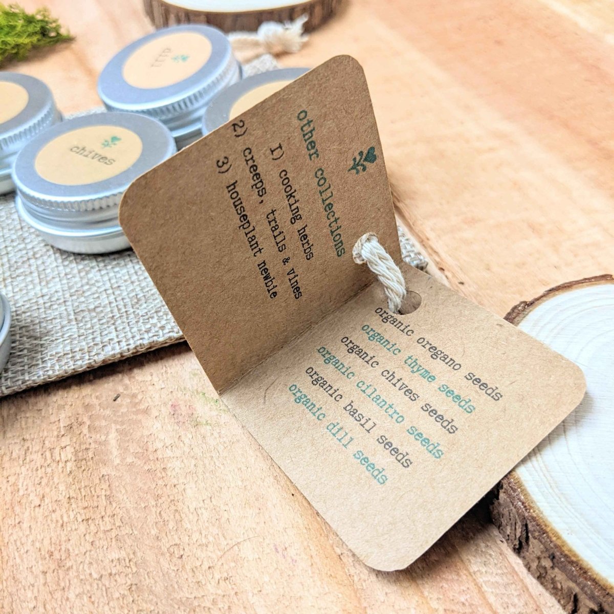 Herb seed collection seed packets with text and hanging cord, on wooden surface