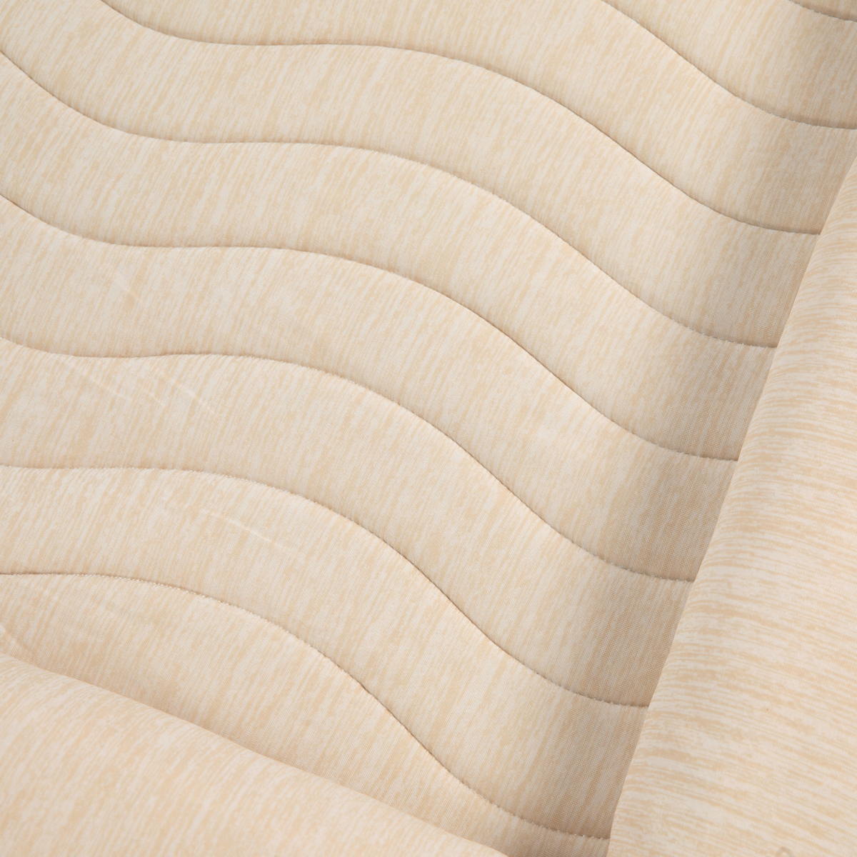 Close-up of arctic sand cooling bed cover fabric with quilted pattern and wave lines