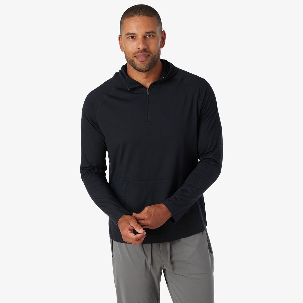 Black quarter-zip hoodie with hood and kangaroo pocket, hands adjusting