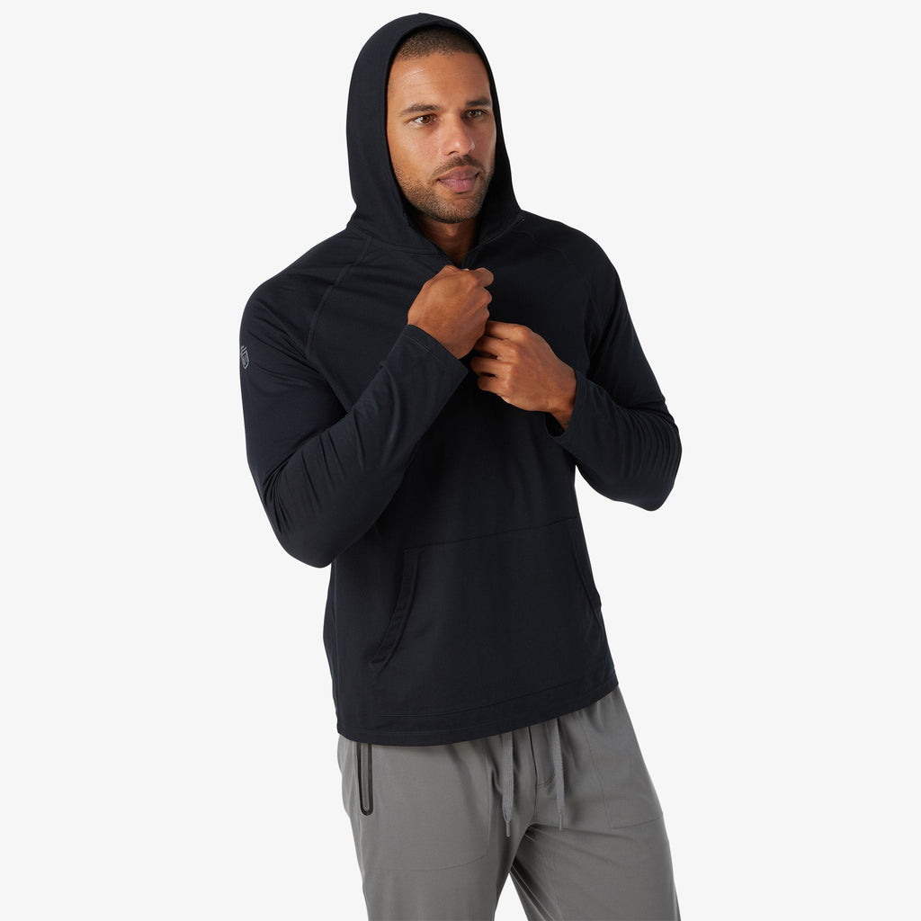 Black hooded quarter-zip pullover, model holding zipper at chest