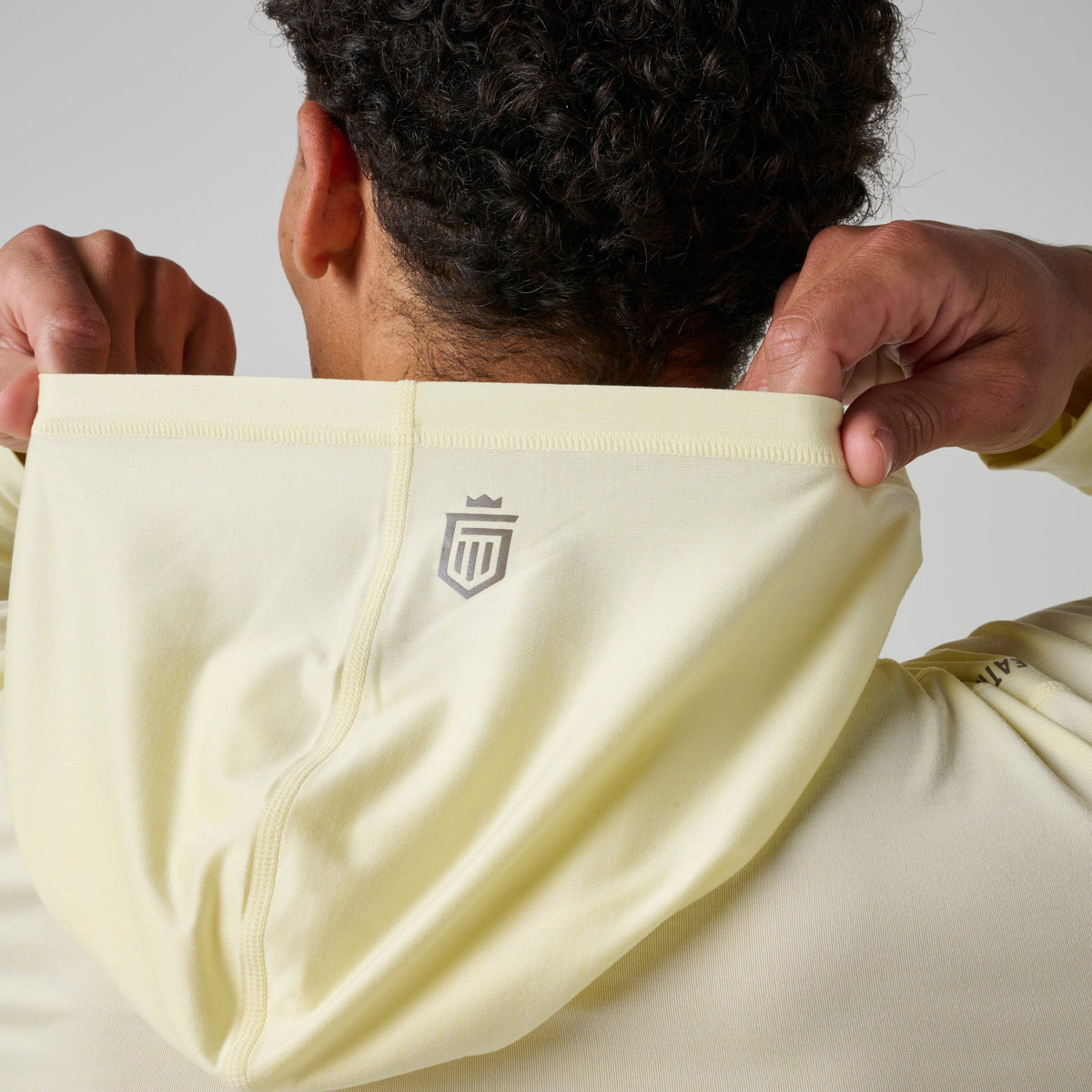 Back view of light yellow hoodie with small chest logo patch