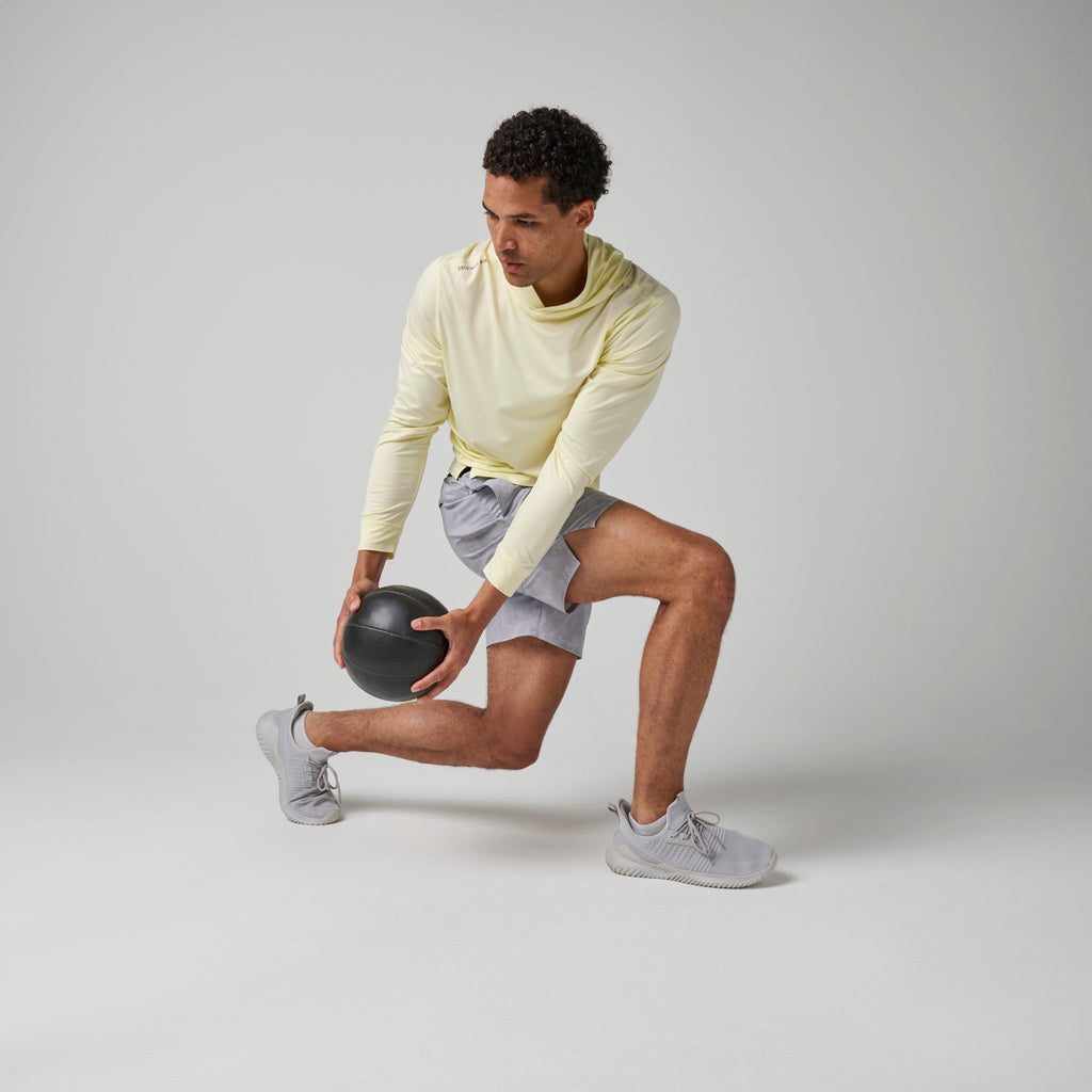 Light yellow hoodie with hood, long sleeves, and kangaroo pocket during stretch