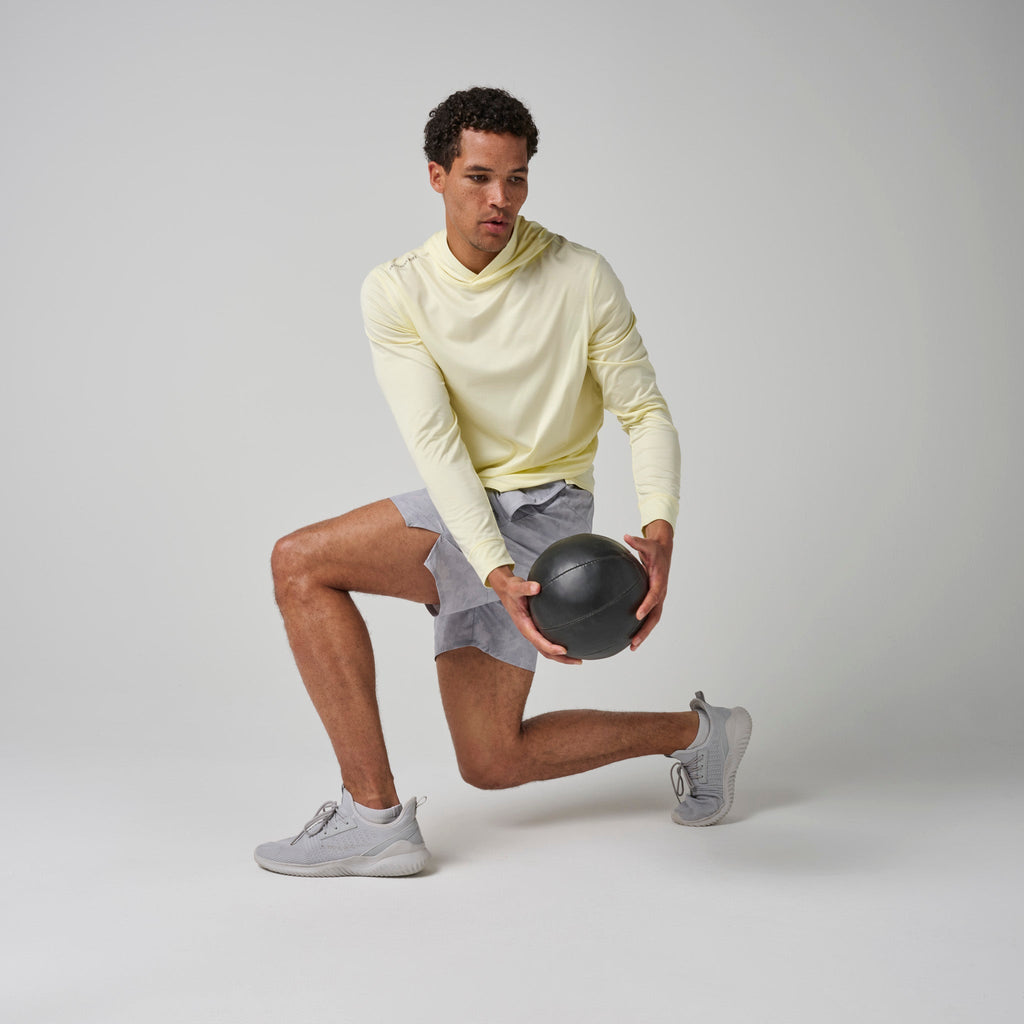 Light yellow tech hoodie worn with gray shorts, hood and kangaroo pocket visible