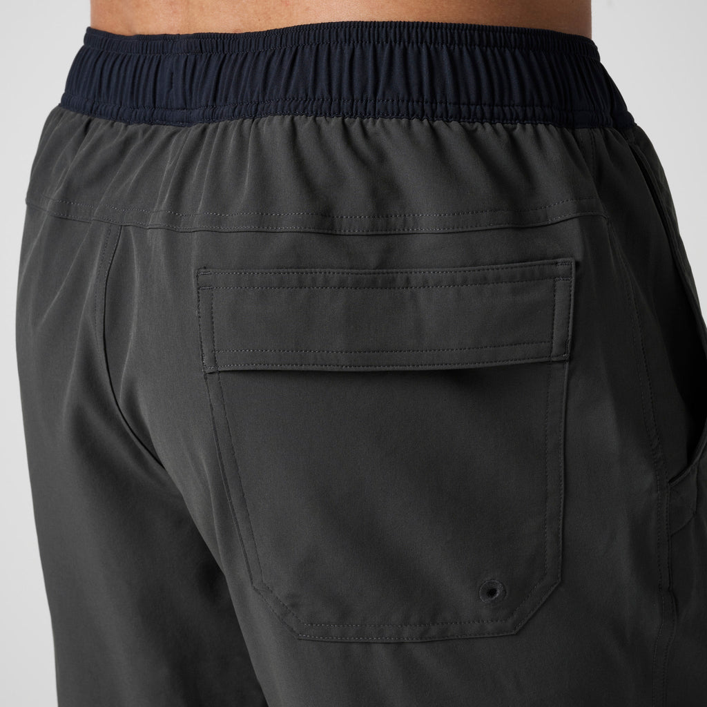 Dark training shorts with front cargo-style pocket and stitched seams
