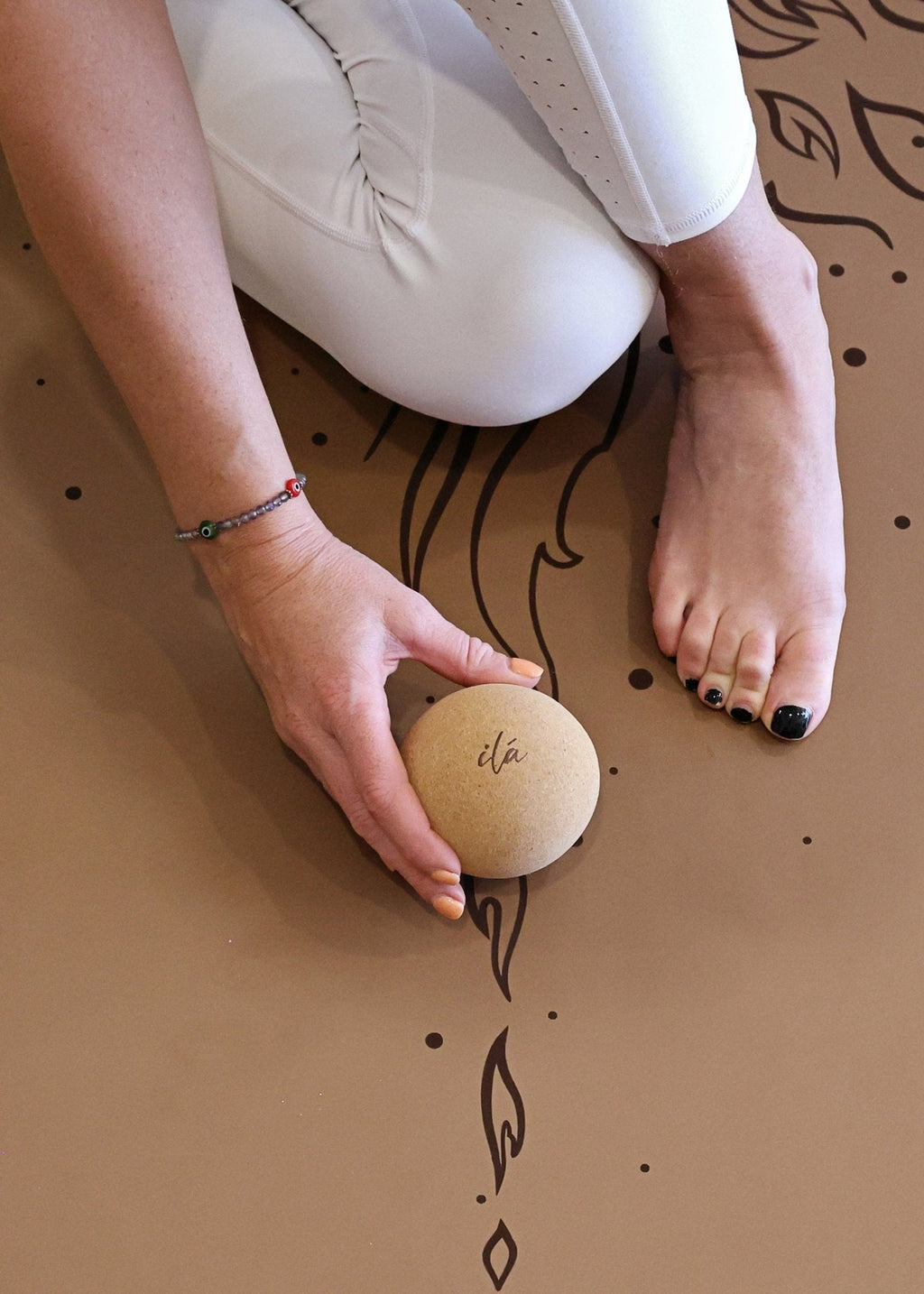 Cork massage ball held in hand during yoga practice