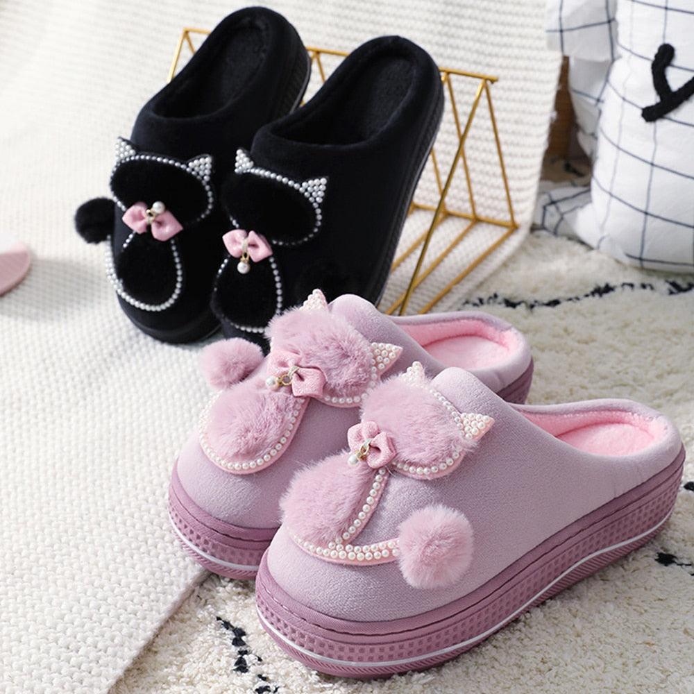 Black and pink fuzzy indoor slippers with bow and pearl embellishments