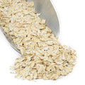 White rolled wheat flakes in a bowl, loose flaky cereal