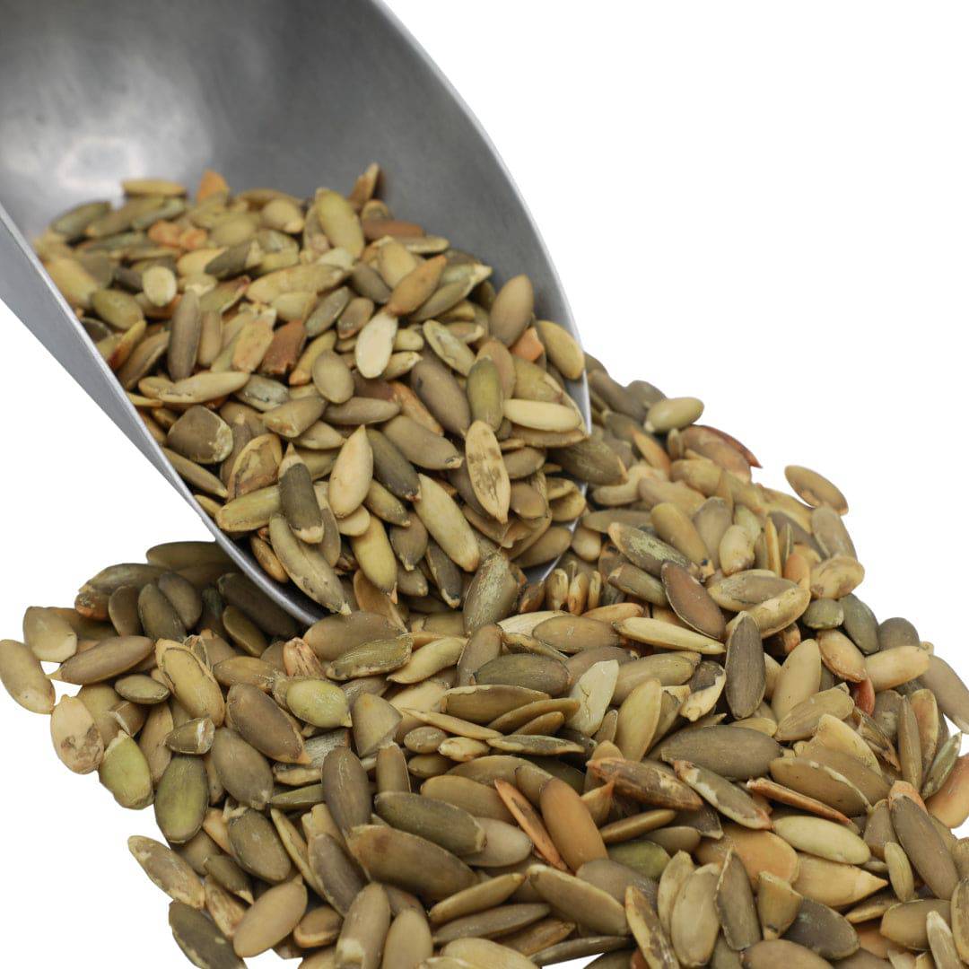 Organic pumpkin seeds (pepitas) in a metal scoop, pale green kernels