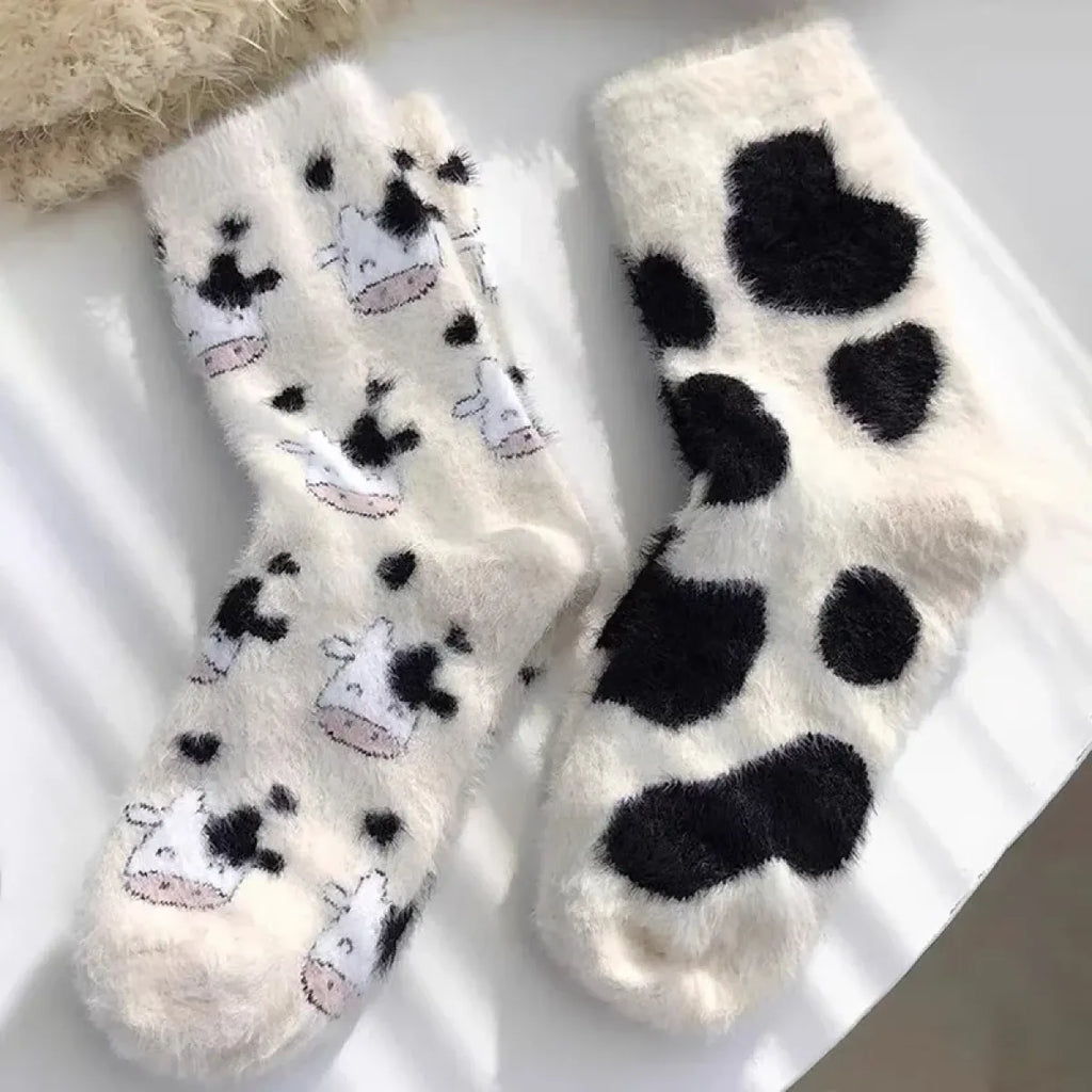 Women’s cow mink velvet socks, white with scattered black cow faces and large paw prints