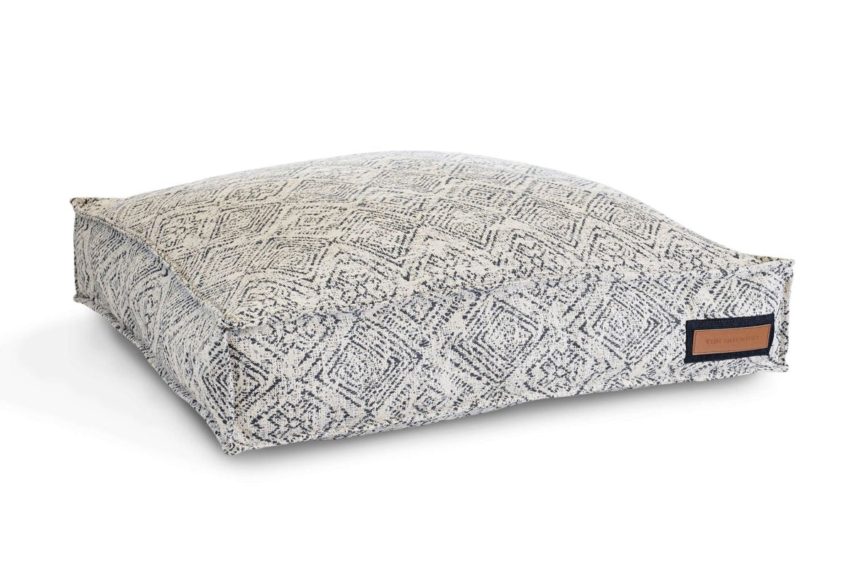 Gray zigzag patterned pet lounger bed with flat bolster and brown label patch