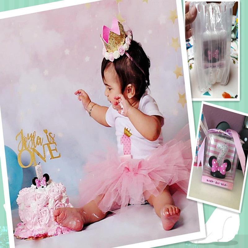 Birthday cake topper scene with silver numeral candle '1' and pink bow on black base