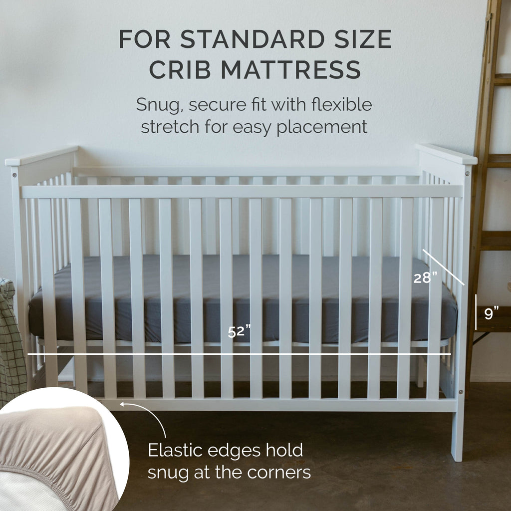 Fitted crib sheet corner detail on a standard crib, showing smooth light fabric edge.