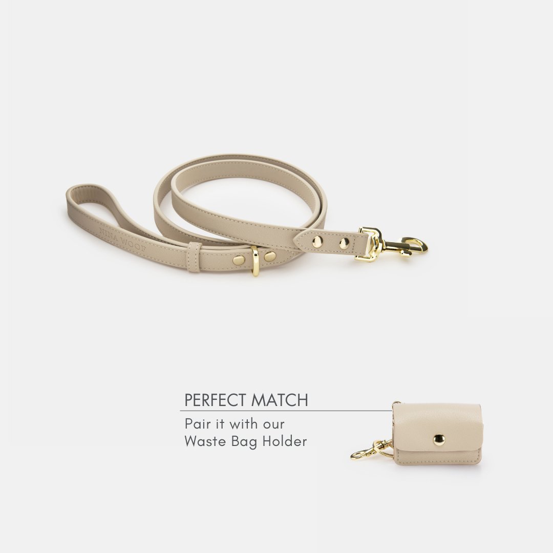 Beige 4ft vegan leather dog leash with gold-tone clasp; matching waste bag holder shown