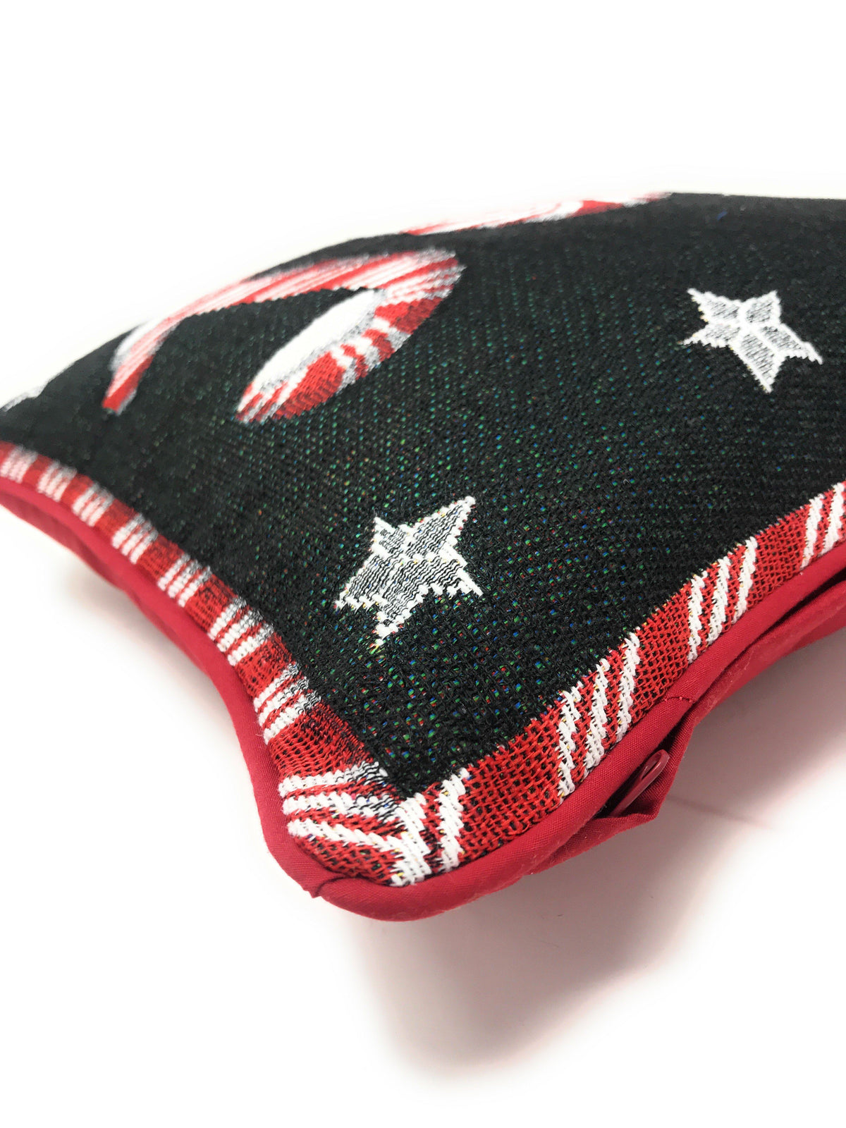 Black pillow cover corner with peppermint swirl, candy cane stripe, and white star