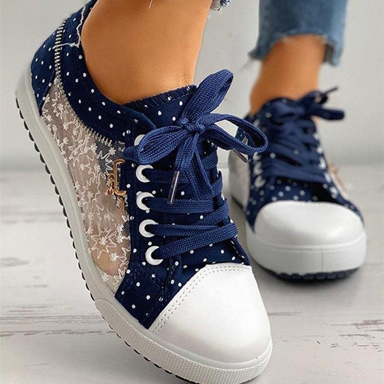 Women’s navy lace-up sneakers with white toe, dotted fabric, and lace bow detail