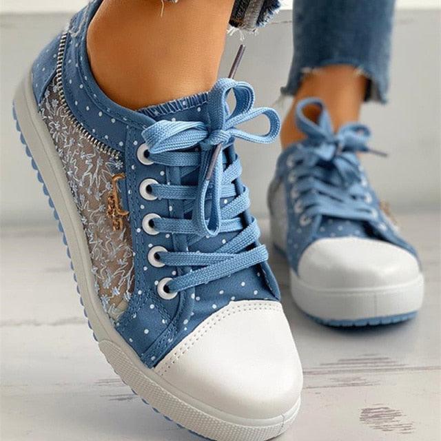 Women’s blue lace-up sneakers with white toe, dotted fabric, and textured side panel