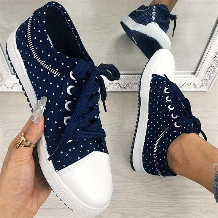 Women’s navy lace-up sneakers with white toe, dotted uppers, and thick white sole