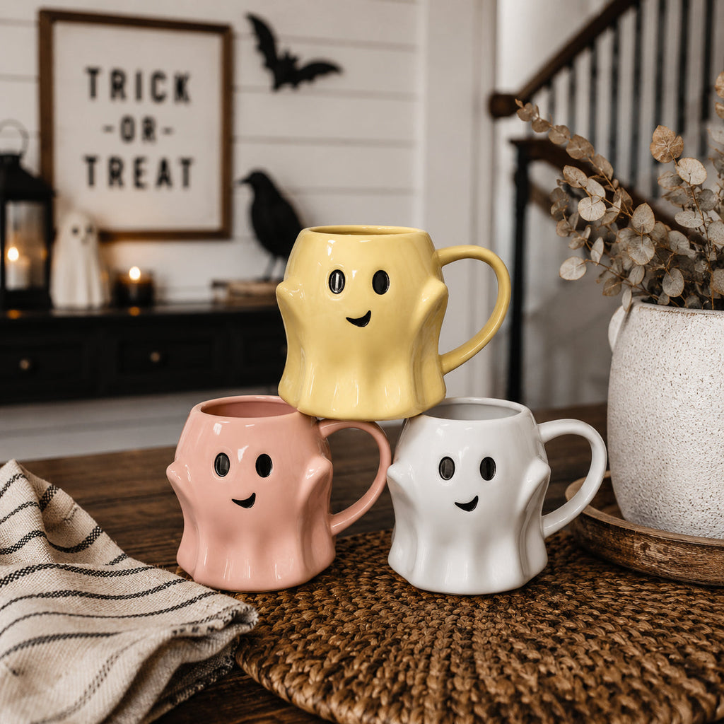 Set of three ghost-shaped mugs with smiley faces in pink, yellow, and white