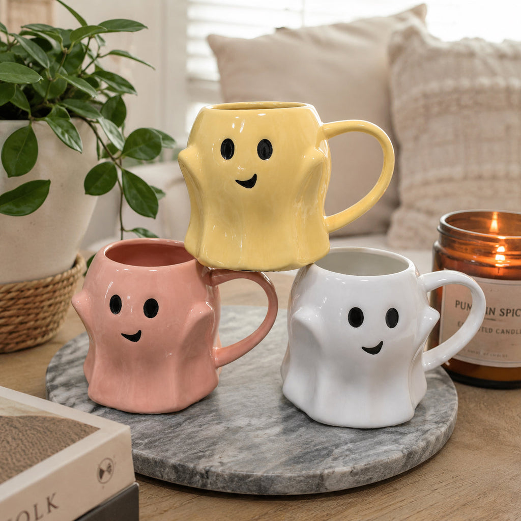 Ghost-shaped ceramic mug set on a tray, yellow, pink, and white