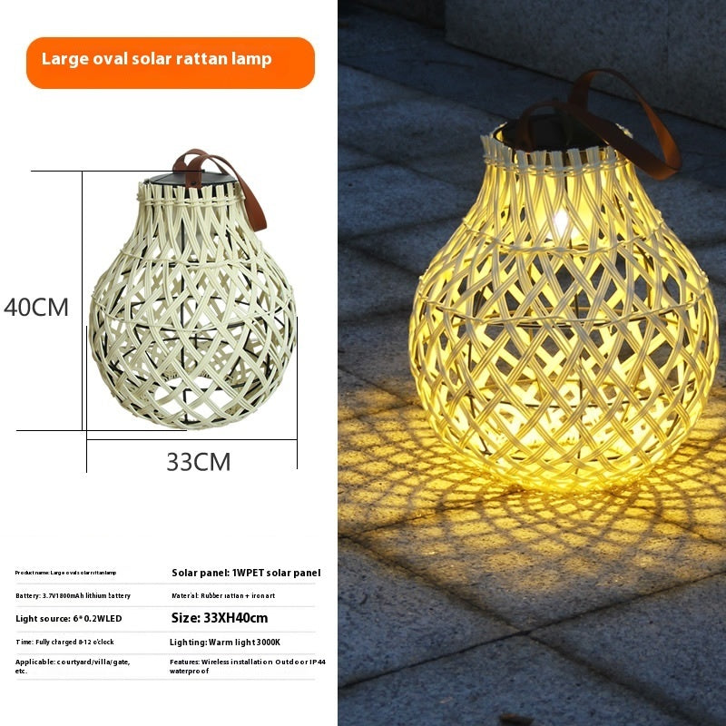 Large oval solar rattan lantern with carry handle, warm glowing lattice weave